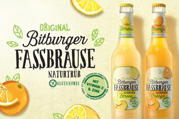 Bitburger Fassbrause Flaschen mit schwarzem Schriftzug vor gelbem Hintergrund