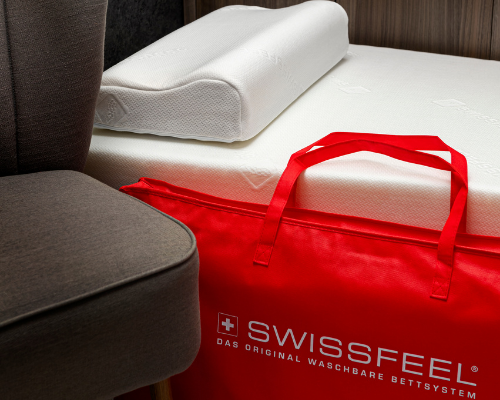 Weißes Kissen und rote Tisch auf Hotelbett