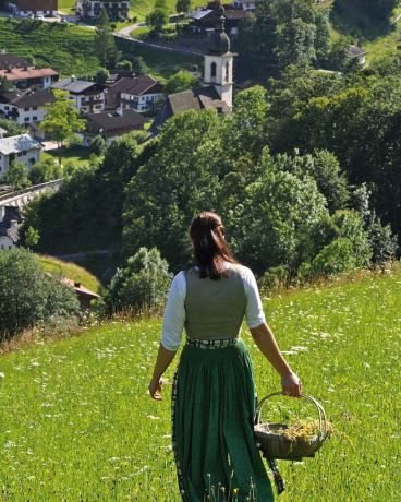 Mitarbeiterin auf einer Blumenwiese vom Berghotel Rehlegg