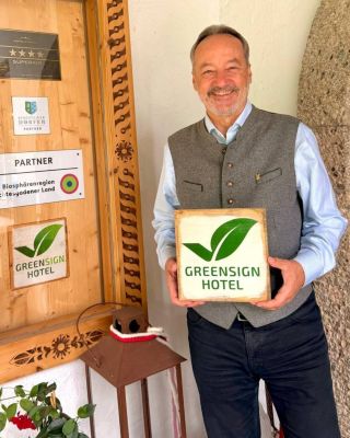 Hannes Lichtmannegger vom Berghotel Rehlegg mit GreenSign Holzschild