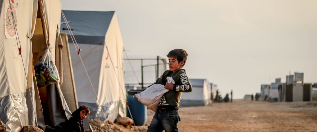 Junge trägt schwere Tasche mit Ware