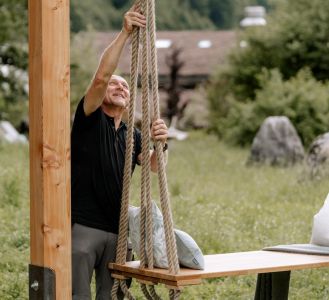 Haustechniker beim Befestigen einer Schaukel im Berghotel Rehlegg